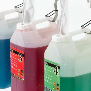 Color-coded soap dispensers in a washroom setting, featuring blue, red, and green liquids for hand hygiene, designed for commercial and public restroom sanitation needs.